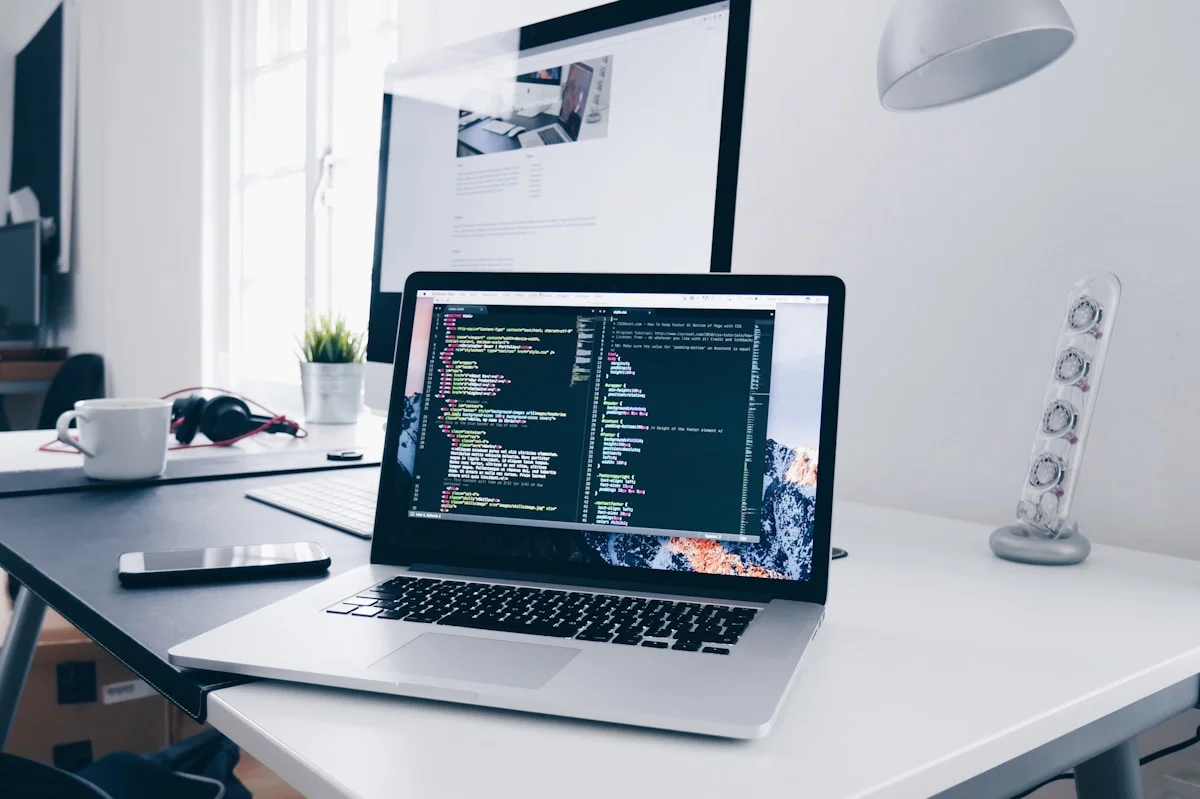 Modern software development workspace with a laptop displaying code